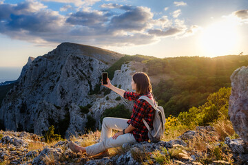 Naklejka na ściany i meble woman hiker enjoy the view at sunset mountain peak cliff