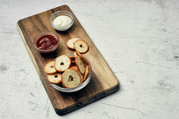 Bread, round crackers on a wooden stand with sauces. Ready meal from the menu. Snack.