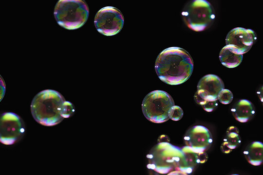 transparent colorful bubbles soap pattern overlay abstract particles splashes of water on black.