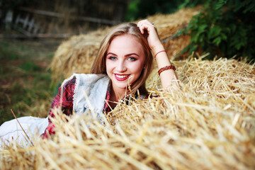 beautiful girl lies in a field on the hay