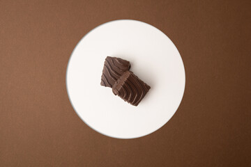 small square chocolate cake on color background