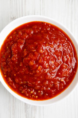 Homemade Tomato Salsa on a white wooden background, top view. Flat lay, overhead, from above. Close-up.