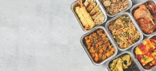 Takeout coronavirus food. Different aluminium lunch box with ravioli, curry chicken  rice, gyoza tempura, noodles vegetables, lentils with pumpkin. covid-19 takeaway  food delivery.