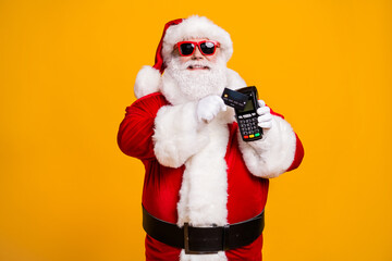 Fototapeta na wymiar Portrait of his he nice attractive cheerful fat overweight Santa using wireless bank card digital terminal paypass system isolated bright vivid shine vibrant yellow color background