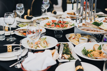 Сatering table with food and glass stemware at restaurant before party 