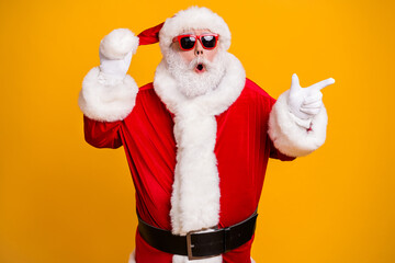 Portrait of his he nice attractive amazed tunned fat Santa demonstrating copy space choose choice shop offer advert ad isolated over bright vivid shine vibrant yellow color background
