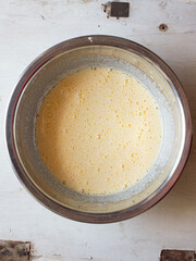 Preparing homemade cake batter, white and old background.
