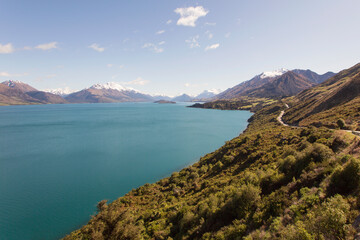 Road trip along the Glenorchy to Queenstown Road with views of snowcapped mountains and Lake Wakatipu - New Zealand South Island.