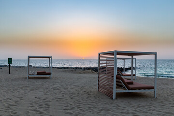Empty sandy beach in Dubai with double sun beds, on new artificial Bluewaters Island, no people due...