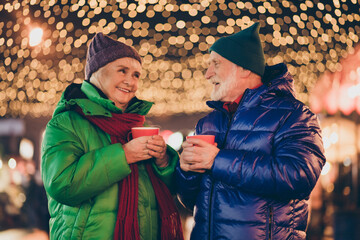 Photo of two old people married couple woman man walk under x-mas christmas tradition garlands...