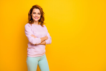 Photo of beautiful curly lady hands crossed business company ceo boss friendly toothy smiling wear pink pullover green trousers isolated yellow color background