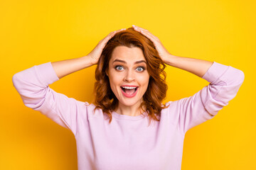 Photo of beautiful ginger lady hands on head open mouth listen cool good news unexpected shocking surprise wear pink pullover shirt isolated yellow color background