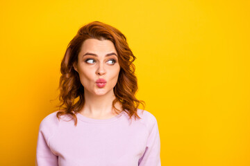 Obraz premium Closeup photo of beautiful pretty ginger lady looking empty space sending air kisses boyfriend shy person avoid eyes contact wear pink sweater shirt isolated yellow color background