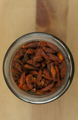 Glass jar viewed from above filled with goji berry on a wooden table
 
