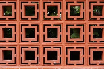 The pattern of Air vents in the brick wall fence.