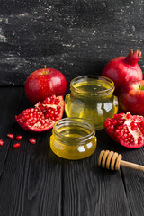Honey, pomegranate and red apples on the black background