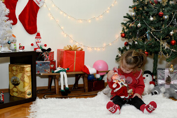Cute little girl with toy in room decorated for Christmas