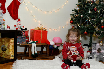 Cute little girl with toy in room decorated for Christmas