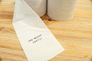 Toilettenpapier auf Holztisch mit Statement auf deutsch zu Berliner Entscheidung Entschluss