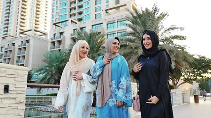 Three friends making shopping and spending time together in Dubai. Group of women wearing traditional uae abaya clothes outdoor 