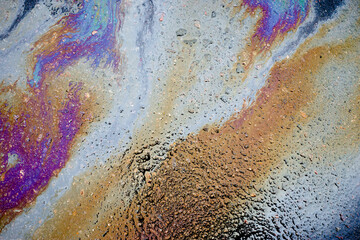 Fototapeta na wymiar Abstract rainbow effect background, colorful gas stain on wet asphalt caused by a leak under a car or truck