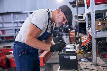 Professional auto mechanic working at car repair station