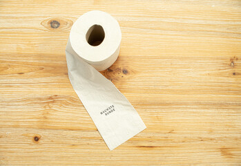 Toilettenpapier auf Holztisch mit Statement auf deutsch zu Berliner Entscheidung Entschluss
