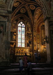 Fototapeta na wymiar Nice low light view of the Baroncelli Chapel located at the end of the right transept in the Basilica di Santa Croce in Florence, Tuscany, Italy. The golden colour comes to light beautifully.