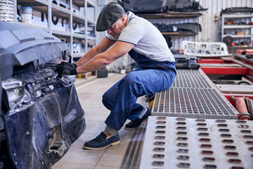 Fototapeta premium Professional auto mechanic working at vehicle repair shop