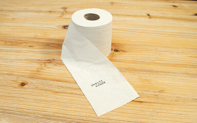 Toilettenpapier auf Holztisch mit Statement auf deutsch zu Berliner Entscheidung Entschluss