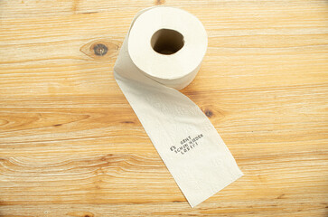 Toilettenpapier auf Holztisch mit Statement auf deutsch zu Berliner Entscheidung Entschluss
