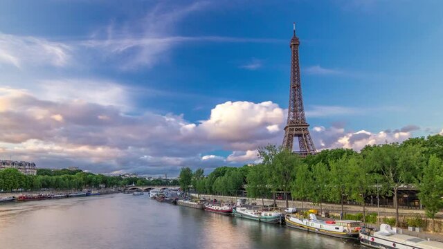 Eiffel Tower with boats in evening timelapse hyperlapse Paris, France. View from Bir-Hakeim bridge before sunset. Blue cloudy sky at summer day
