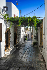 The small town of Lindos hides behind the mighty rock of the acropolis separating two coves with...