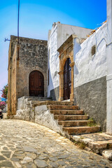 The small town of Lindos hides behind the mighty rock of the acropolis separating two coves with sandy beaches      