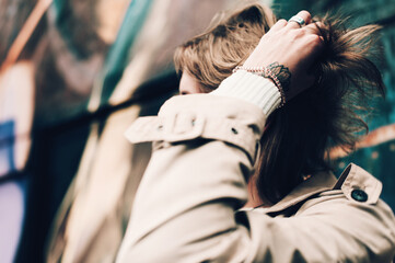Close-up portrait Beautiful elegant woman wearing beige coat and black hat. Trendy casual outfit....