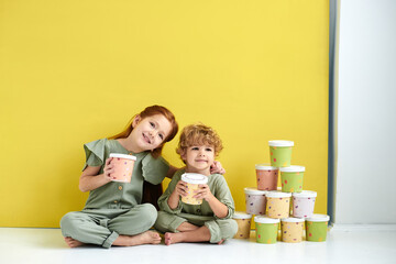 Two little boy and girl in with paper boxes. Design and advertising idea for packaging.