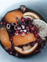 Winter tea with oranges, frozen cranberries, cinnamon sticks, star anise. Photo