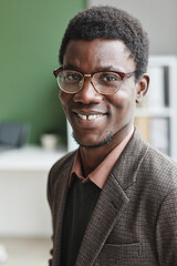 Portrait of successful African man in eyeglasses and in casual clothing smiling at camera