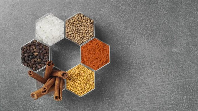 Spices in hexagonal jars on a stone surface. Stop motion animation