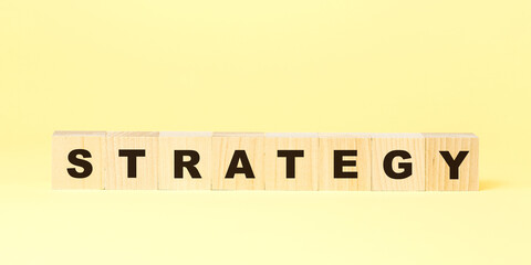word strategy made with wooden blocks on yellow background