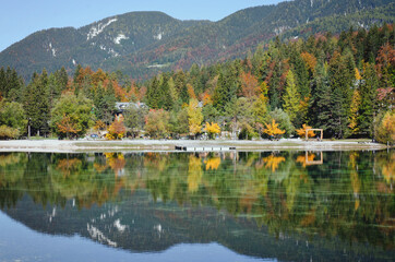 Beautiful view on green lake in the mountains against the colorful autumn forest in slovenian alps. 