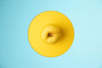 yellow apple in yellow and blue background