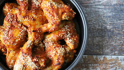Baked chicken wings with sesame seeds in a skillet. Junk food. Delicious buffalo wings.
