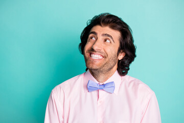 Photo portrait of cheerful man looking at blank space isolated on pastel cyan colored background