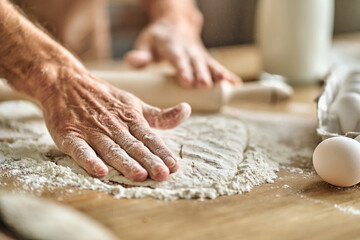 Baker hands in flour cooking dough for bread