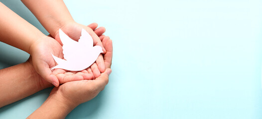 hands holding paper white bird, world peace day concept.