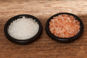 Salt; Himalayan pink salt crystals and sea salt, photo on wooden background.