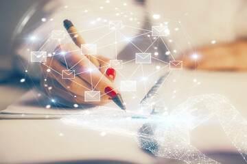 E-mail envelop theme hologram over hands taking notes background. Concept of electronic mail. Double exposure