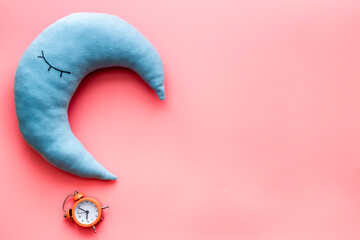 Flat lay of sleeping pillow with alarm clock, top view