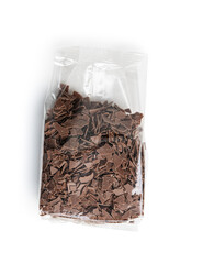 Grated dark chocolate in plastic bag. Chocolate flakes isolated on white background.